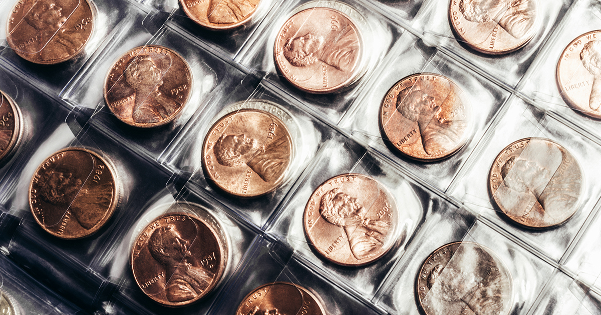 A close-up view of various coins neatly arranged in a transparent plastic case.